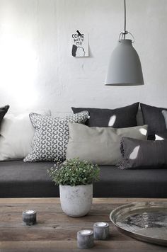 a living room filled with lots of furniture and pillows on top of a wooden table