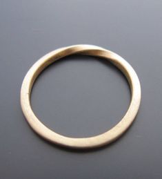 a close up of a gold ring on a black surface with no one around it