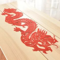 a wooden table topped with red paper cut outs