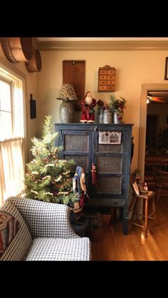 a living room filled with furniture and a christmas tree on top of a wooden table