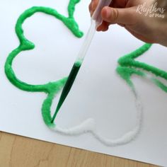 someone is painting the outline of a shamrock with green paint