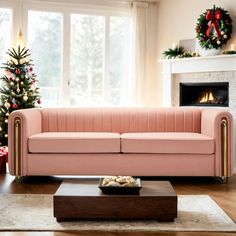 a living room with a pink couch and christmas tree in the corner by the window