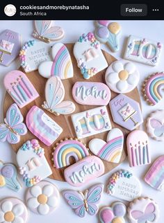 decorated cookies are arranged in the shape of rainbows, clouds, and unicorns