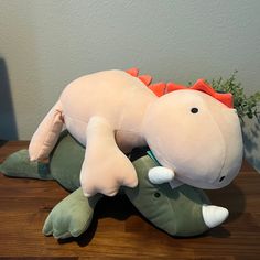 a stuffed animal laying on top of a wooden table