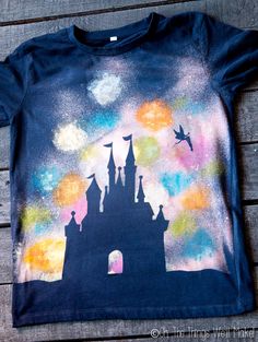 a t - shirt with an image of a castle painted on the front and back