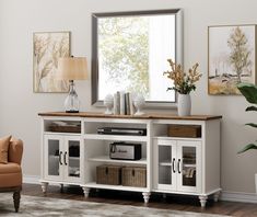 a living room scene with focus on the tv and entertainment center, which is decorated in neutral tones