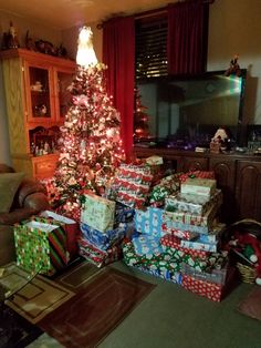 a christmas tree with presents under it in a living room