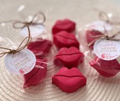 some candy shaped like lips sitting on top of a white plate with tags attached to them