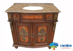 a bathroom vanity with marble top and carved wood design on the cabinet door, which is decorated in gold leaf designs