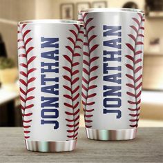 two red and white baseball themed tumblers sitting on top of a table