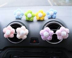 four colorful hair clips sitting on the dashboard of a car