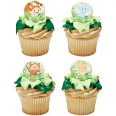 four cupcakes decorated with jungle animals on top of each other and green bows