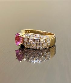 DeKara Designs Classic Metal- 18K Yellow Gold, .750. Stones- 1 Genuine Oval Pink Sapphire 1.26 Carats, 22 Baguette Diamonds, 32 Round Diamonds, G-H Color VS2 Clarity 1.55 Carats. Size- 6 1/2. FREE SIZING Handmade Beautiful Pink Sapphire Diamond Baguette and Round Baguette Engagement Ring Created in 18K Yellow Gold. There is a beautiful and fiery hot pink oval shaped genuine sapphire in the center that is professionally set in between four prongs. There are 11 beautifully and uniquely set baguett Luxury Pink Oval Cluster Ring, Luxury Emerald Cut Rings With Aaa Quality, Luxury Oval Cluster Ring In Yellow Gold, Luxury Emerald Cut Rings Of Aaa Quality, Luxury Emerald Cut Aaa Quality Rings, Oval Diamond Rings With Baguette Diamonds, Oval Rings With Baguette Diamonds, Luxury Ruby Ring With Baguette Cut Center Stone, Luxury Oval Cluster Ring For Wedding