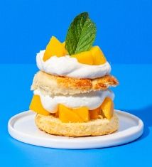 a stack of food sitting on top of a white plate next to a blue background