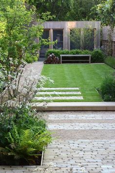 an outdoor garden with grass and stepping stones