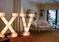 lighted letters spelling out the word vix in front of a living room with large windows