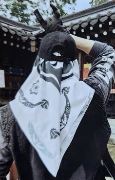 a person wearing a black and white mask with a bandanna around their neck, covering his face