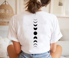 "Moon Phases Shirt, Moon Shirt, Moon Phases Tshirt, Moon Tee, Moon Phases Tee,Celestial Shirt, Space Lover Shirt, Boho Shirt,Back Printed The Design will be printed to the back of the shirt in white color on dark colors and in black color on the light colors. Please don't hesitate to contact me if you need anything special! HI there! I'm Daisy, the owner of DaisyTeeUS. I'm so glad to see you here. My priority is to make you happy with your purchase. Please contact me if you have any questions or Moon Phase Shirt, Boho Tshirt Design, Moon Tshirt, Moon Phases Shirt, Celestial Shirt, Merch Ideas, Trendy Shirt Designs, Space Lovers, Moon Shirt