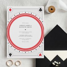 the wedding stationery is laid out on top of black and white paper