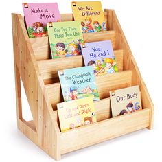 children's books are arranged in a wooden book holder with dividers for each section