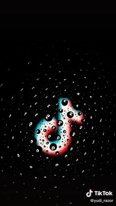 the letter s is made out of water droplets on a black background with red and blue bubbles