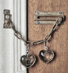 two heart shaped key chains attached to a wooden door with a lock on the side