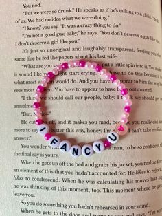 a pink beaded bracelet that says, i love you and has the word fancy on it