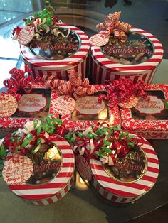 several red and white boxes with christmas decorations on the top one is filled with candy