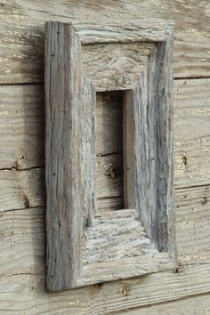 an old wooden frame hanging on the side of a building