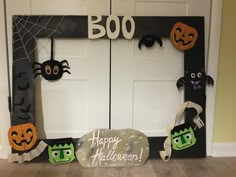 halloween decorations are displayed in front of a door with the words boo written on it