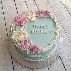 a birthday cake decorated with flowers and the words happy birthday written in frosting on it