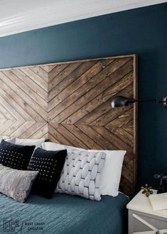 a bedroom with blue walls and wooden headboard