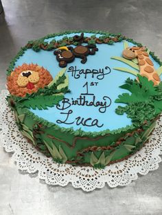 a birthday cake decorated with animals and plants