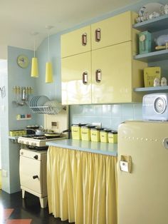 a kitchen with yellow cabinets and blue walls