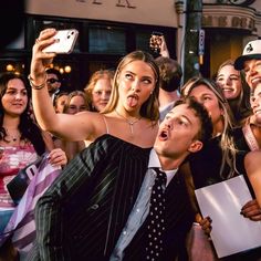 a group of people taking pictures with their cell phones