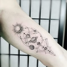 a black and white photo of a tattoo on the arm with an image of planets