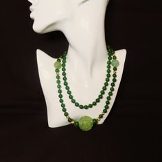 On offer is this spectacular Vintage Chinese 36 Inches Long Green Nephrite Jade Beaded Necklace with 14 Karat Yellow Gold Corrugated Spacer Beads and a huge roung central Hand Carved and Pierced Translucent Green Jade Pendant with Two Shou Design Carved Green Jade Beads.  The necklace is hand knotted with green silk cord with no clasp because it easily slips over your head.  The green Nephrite Jade is highly polished so it gleams with a deep luster.  The Nephrite Jade beads measure 8mm in diamet Antique Carved Jade Pendant And Beaded Necklace, Elegant Green Onyx Beaded Necklaces, Elegant Beaded Green Onyx Jewelry, Elegant Green Onyx Beaded Jewelry, Elegant Round Jade Beads, Vintage Jade Jewelry Hand-strung, Green Jade Long Necklace, Green Single Strand Beads And Cabochons As A Gift, Vintage Hand-strung Jade Jewelry