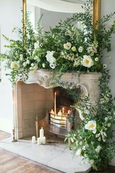 a fireplace with flowers and candles on it