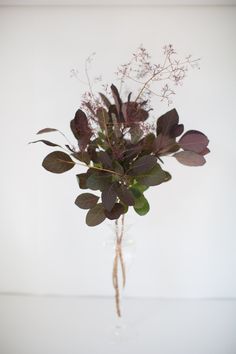 a vase filled with lots of flowers on top of a table