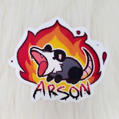 a sticker with an image of a rat on fire and the word arson