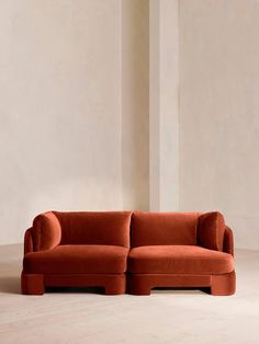 an orange couch sitting on top of a white floor