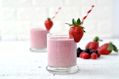 two glasses filled with smoothie and strawberries