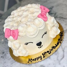 a birthday cake with white frosting and pink bows on it's head that says happy birthday