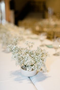 small white flowers are in a vase on the table at a wedding reception or party