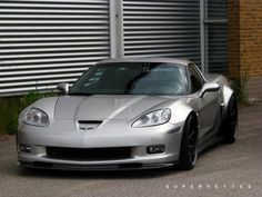 a silver sports car parked in front of a building