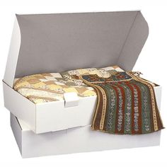 an open white box with a quilt on the bottom and inside, sitting on top of a table