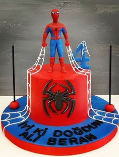 a spiderman birthday cake on top of a red and blue base with the words my dogon is here