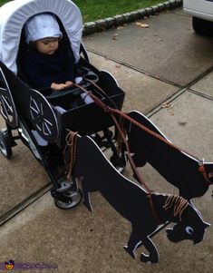 a child in a stroller with a paper cutout of a dog on it