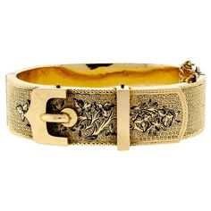 Stunning Victorian buckle motif yellow gold buckle stiff hinged bangle bracelet accented with black enamel detail stippled textured embossed foliate designs yellow gold safety chain hinged side clasp 3/4" wide, holds as 10-12kt gold but note that this bracelet is of the age where components may be a combination of solid gold and rolled gold which was typical of the period. The interior measures at least 6.75" to 7.0" in width. Excellent condition. Measurements: 0.75" Width Interior Measures 6.75 Victorian Pendant Necklace, Victorian Pendants, Yellow Gold Bangle, Bangles Making, Bangle Bracelet Set, Buckle Bracelet, Victorian Gold, Safety Chain, Hinged Bracelet