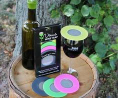 a bottle of wine and some coasters on a tree stump